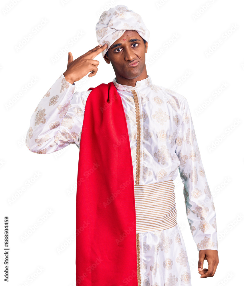 African handsome man wearing tradition sherwani saree clothes shooting and killing oneself pointing hand and fingers to head like gun, suicide gesture. African handsome man wearing tradition sherwani saree clothes shooting and killing oneself pointing hand and fingers to head like gun, suicide gesture.