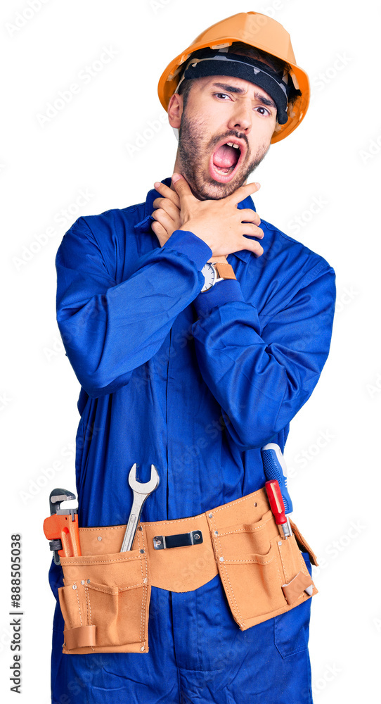 Young hispanic man wearing worker uniform shouting suffocate because painful strangle. health problem. asphyxiate and suicide concept. Young hispanic man wearing worker uniform shouting suffocate because painful strangle. health problem. asphyxiate and suicide concept.
