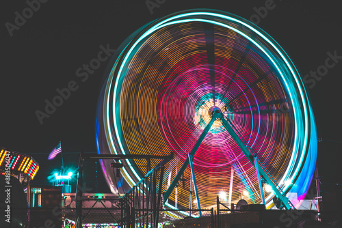 Long Exposure neon Ferris Wheel at a fair at night, amusement park, carnival