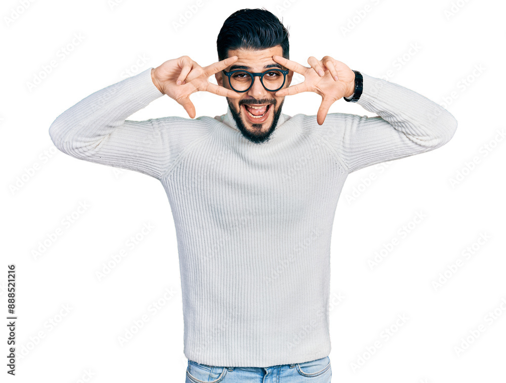 Young arab man with beard wearing elegant turtleneck sweater and glasses doing peace symbol with fingers over face, smiling cheerful showing victory Young arab man with beard wearing elegant turtleneck sweater and glasses doing peace symbol with fingers over face, smiling cheerful showing victory