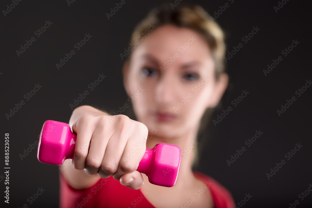 Woman lifting pink dumbbell for fitness and wellness Woman lifting pink dumbbell for fitness and wellness