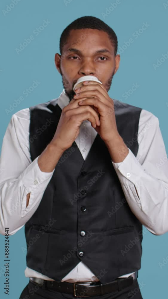 Vertical Video Doorman employee drinking a cup of coffee after a long night shift, working in hospitality industry and tourism. Porter bellboy serving a cool caffeine refreshment, concierge services Vertical Video Doorman employee drinking a cup of coffee after a long night shift, working in hospitality industry and tourism. Porter bellboy serving a cool caffeine refreshment, concierge services