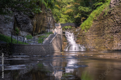 Hiking path and stairs leading to a beautiful cascading waterfall surrounded by lush greenery. Cascadilla Gorge in Ithaca New York- Finger Lakes Region
 photo