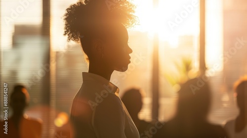 A confident African American businesswoman stands in front of an office boardroom.