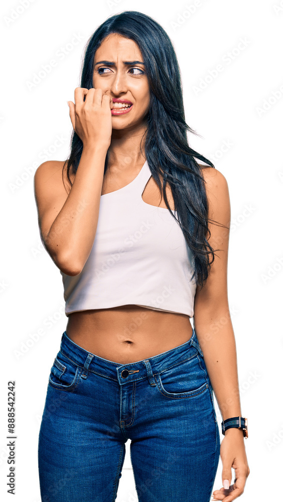 Beautiful hispanic woman wearing casual clothes looking stressed and nervous with hands on mouth biting nails. anxiety problem. Beautiful hispanic woman wearing casual clothes looking stressed and nervous with hands on mouth biting nails. anxiety problem.