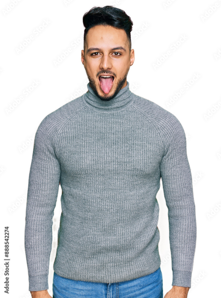 Young arab man wearing casual clothes sticking tongue out happy with funny expression. emotion concept. Young arab man wearing casual clothes sticking tongue out happy with funny expression. emotion concept.