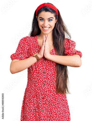Sticker Brunette teenager girl wearing summer dress praying with hands together asking for forgiveness smiling confident