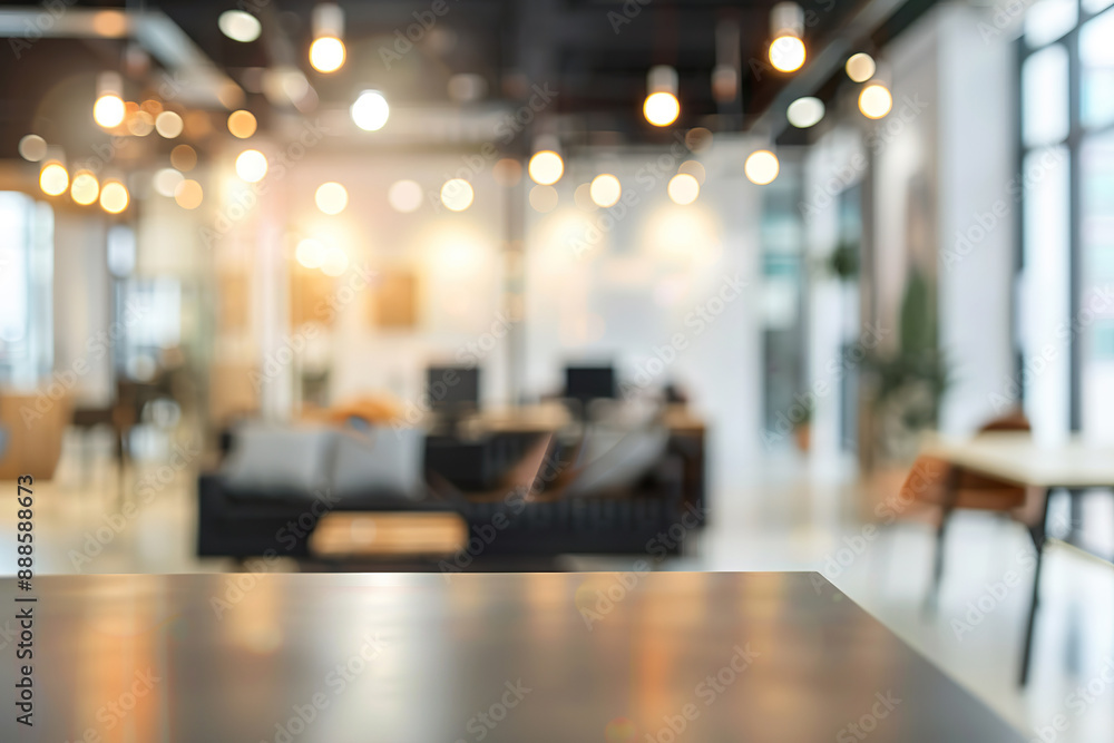 A blurry image of a large office space with a person sitting at a desk.
