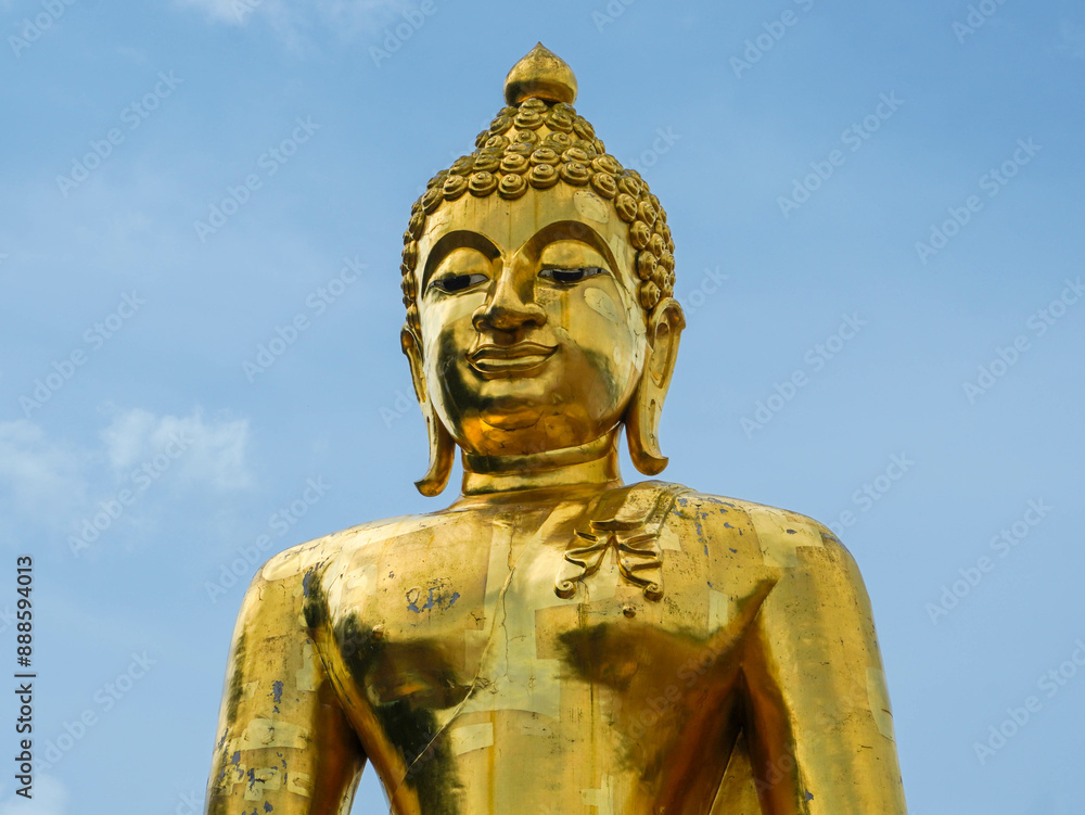 Big golden Buddha statue on a bright sky background - Landmark Famous sculpture statue in Thailand Temple. Big golden Buddha statue on a bright sky background - Landmark Famous sculpture statue in Thailand Temple.