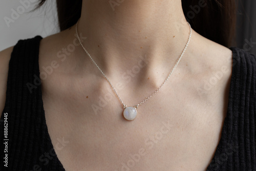Foto Silver necklace with moonstone on female neck