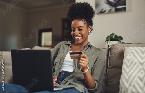 Woman, laptop and relax with credit card on sofa for online shopping for home decor, browsing and digital marketplace. Girl, technology and internet banking in house for virtual retail and buying. photo