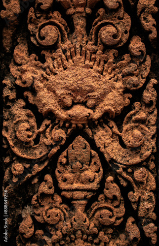 Detailed carved bas relief in red sandstone of mythological Kala at Banteay Srei -citadel of women and beauty- Hindu Temple dedicated to god Shiva and Parvati, Siem Reap, Cambodia.