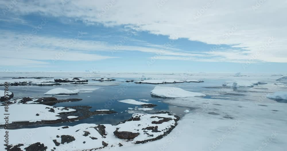 Breathtaking journey over frozen Antarctica landscape. Snow covered Antarctic coast aerial view. Polar ocean icebergs under blue sky. Arctic shoreline. South Pole travel and exploration. Drone shot
