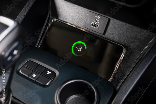 Wireless mobile charger in the modern car. Portable wireless car charger for smartphone.
