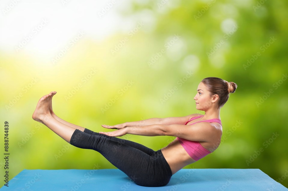 Fototapeta premium Young woman stretching body, doing yoga.