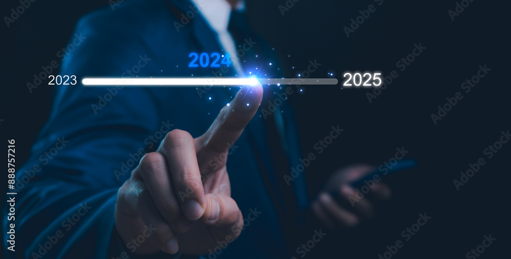 Fototapeta premium Businessman touch on loading progress from 2023 to 2025,Planning and challenge strategy in new year 2024 Concept. New business startup to 2025. New year 2025 is loading, calendar date, end of the year