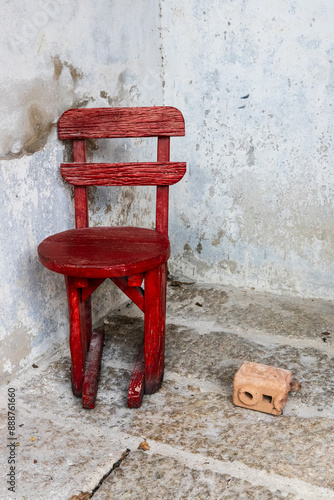 Wallpaper Mural Cornered.  Old red wooden chair and a brick in a corner against a wall in So Heng Tai Mansion, Talat Noi, Bangkok. Torontodigital.ca