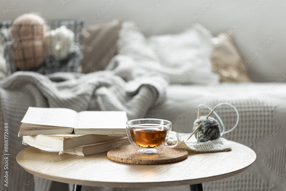 Cozy composition with a cup of tea, a candle and knitted elements. Cozy composition with a cup of tea, a candle and knitted elements.