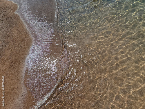 Sea waves on the soft sandy shore of Mediterranean coast. photo