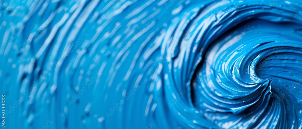 A tight shot of a blue item speckled with water droplets on its surface, contrasted by a centered black object A tight shot of a blue item speckled with water droplets on its surface, contrasted by a centered black object