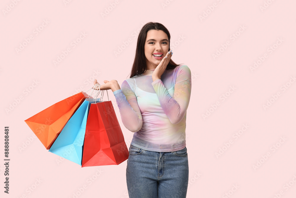 Beautiful young happy woman with shopping bags on pink background Beautiful young happy woman with shopping bags on pink background