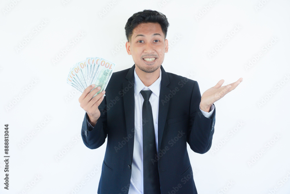 Excited young Asian business man 20s wearing suit standing hold fan of cash money in dollars banknotes spreading hands isolated Excited young Asian business man 20s wearing suit standing hold fan of cash money in dollars banknotes spreading hands isolated