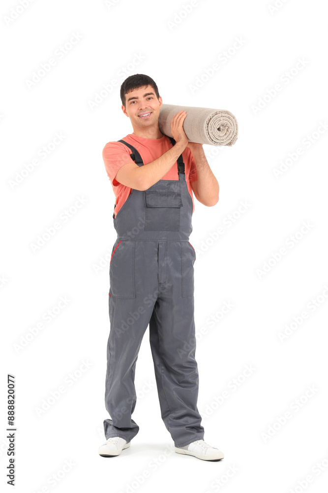 Fototapeta premium Young loader carrying rolled carpet on white background