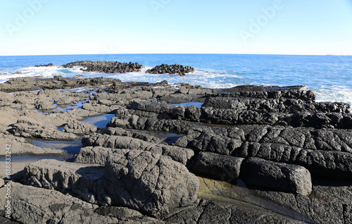 Winter view of volcanic rocks with pond against wave and sea horizon at Gyeongju Yangnam Columnar Joint Group of Eupcheon-ri near Gyeongju-si, South Korea
 photo