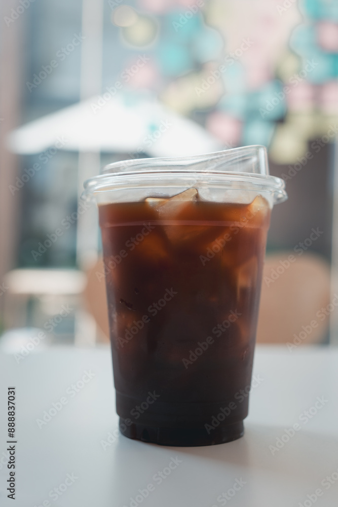 Closeup of take away plastic cup of iced black coffee Closeup of take away plastic cup of iced black coffee