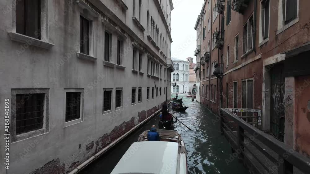 Gondolas gliding through a canal between historic buildings in Venice, Italy. Static shot Gondolas gliding through a canal between historic buildings in Venice, Italy. Static shot
