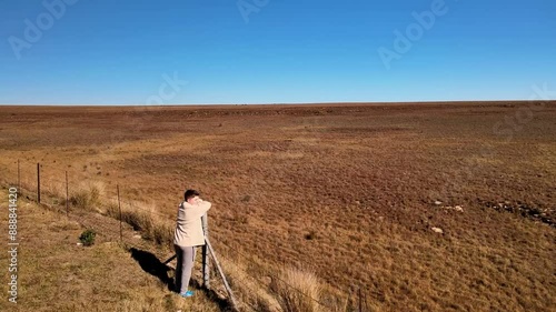 Wallpaper Mural Caucasian boy resting on a fence post, gazing into the vast, open grasslands in complete freedom Torontodigital.ca