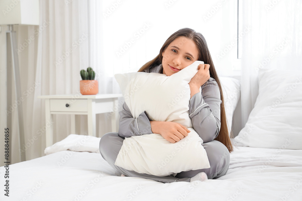 Young woman hugging pillow in bedroom Young woman hugging pillow in bedroom