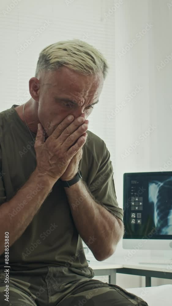 Vertical shot of anxious ex-soldier having panic attack when visiting doctors office Vertical shot of anxious ex-soldier having panic attack when visiting doctors office