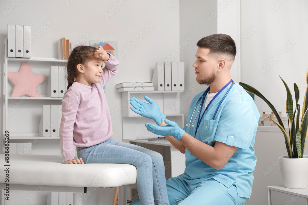 Obraz premium Sick little girl sitting on couch at pediatrician's office