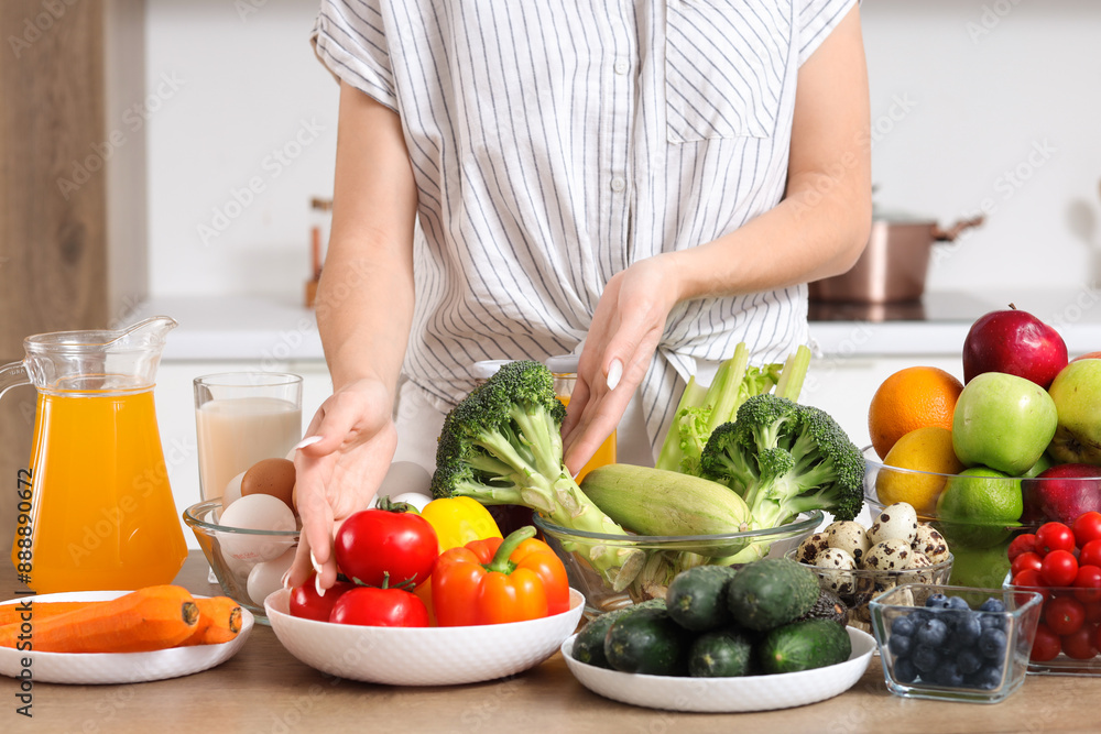 Young woman with healthy food on table in kitchen, closeup. Diet concept Young woman with healthy food on table in kitchen, closeup. Diet concept