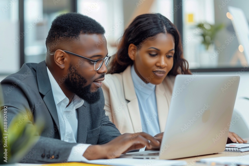 Businessman and woman working together on laptop in the office. The man is showing documents, using the computer for a meeting presentation. mature businesspeople discussing a project at a work desk. Businessman and woman working together on laptop in the office. The man is showing documents, using the computer for a meeting presentation. mature businesspeople discussing a project at a work desk.