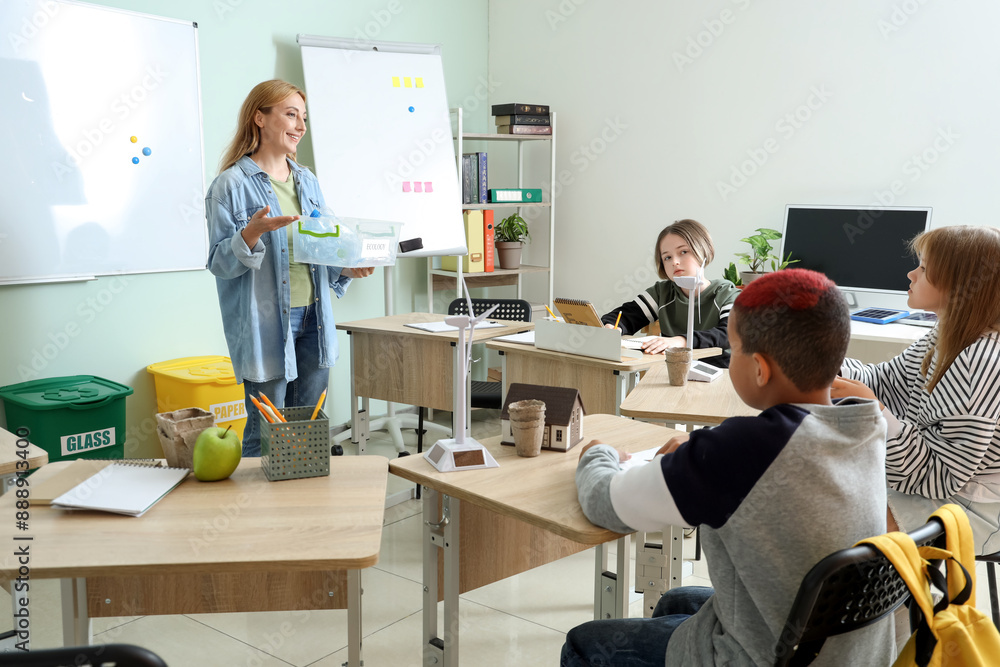 Female teacher with plastic garbage conducting Ecology lesson to pupils in classroom Female teacher with plastic garbage conducting Ecology lesson to pupils in classroom