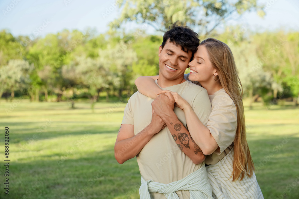 Beautiful young happy couple hugging in summer park Beautiful young happy couple hugging in summer park