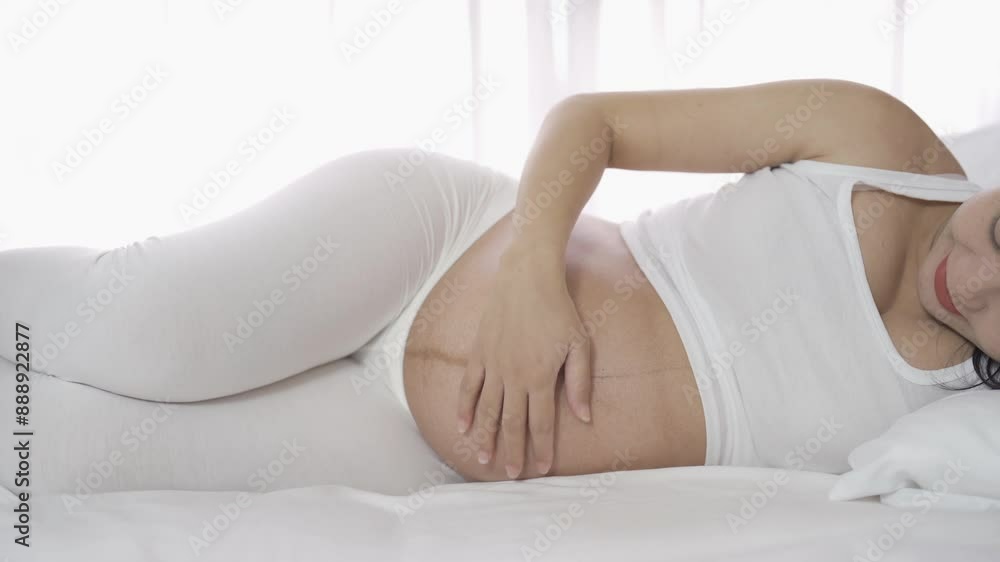 A Portrait of happy Asian pregnant woman in bedroom at home. Having a baby. Family people lifestyle. Love. A Portrait of happy Asian pregnant woman in bedroom at home. Having a baby. Family people lifestyle. Love.