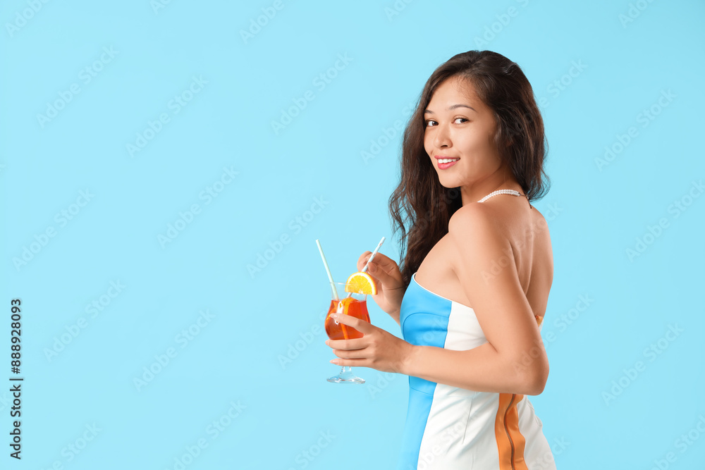 Young Asian woman with aperol spritz cocktail on blue background Young Asian woman with aperol spritz cocktail on blue background