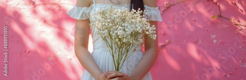 Bride Holding White Babys Breath Bouquet Against Pink Wall