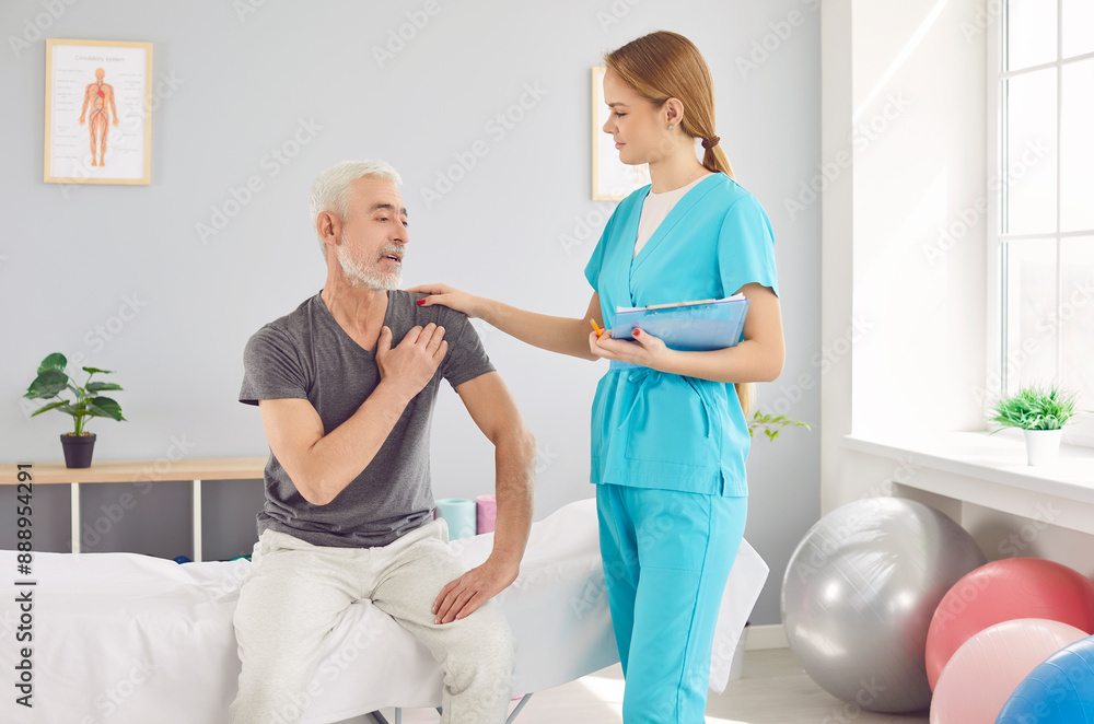 Obraz premium An elderly man complains of shoulder pain to a woman doctor, a rehabilitation specialist. Rehabilitation center concept. The process of recovery after injury. Examination at the medical center