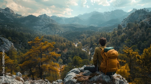 Wallpaper Mural The young tourist with a yellow backpack sits on a rocky ledge, soaking in the beautiful natural surroundings. Hiking and climbing through the forest and mountains have brought him great happiness. Torontodigital.ca