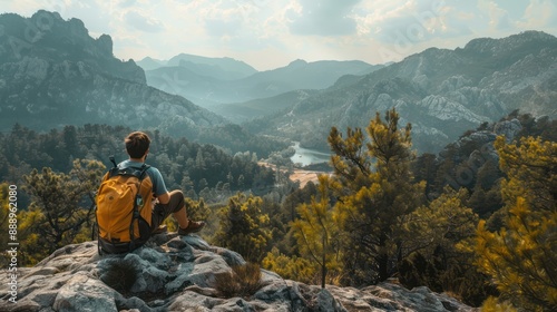 The young tourist with a yellow backpack sits on a rocky ledge, soaking in the beautiful natural surroundings. Hiking and climbing through the forest and mountains have brought him great happiness.