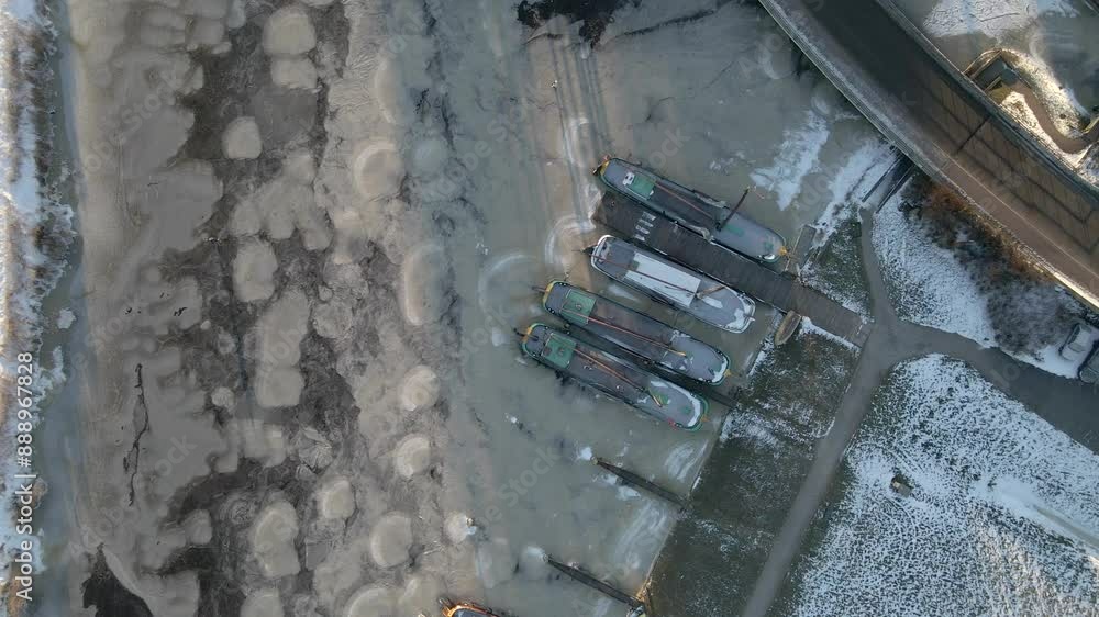 Aerial view of frozen river with boats and snow in winter, Sloten, Friesland, Netherlands.