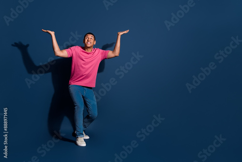 Wallpaper Mural Photo of young guy wearing pink t shirt promoting two offers propositions heavy weight above head isolated over dark blue color background Torontodigital.ca