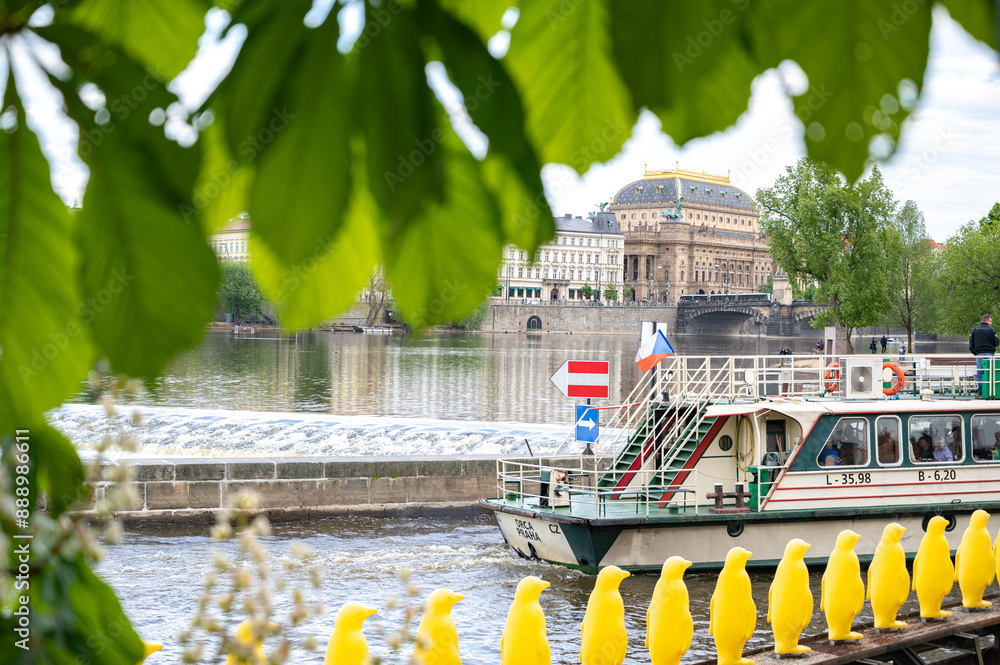 Prague, Czech Republic. Pleasure boat on the river in Prague. Chestnut leaves in the foreground, selective focus.