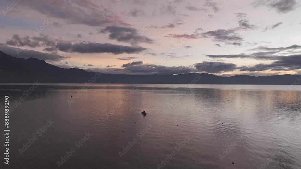 Aerial view of tranquil sunrise over Lake Atitlan with majestic mountains and serene water, San Pedro La Laguna, Guatemala. Aerial view of tranquil sunrise over Lake Atitlan with majestic mountains and serene water, San Pedro La Laguna, Guatemala.