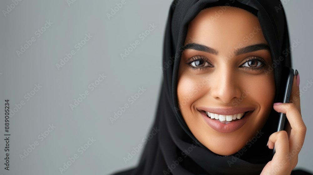 Elegant Arabian woman in black attire chatting on cellphone at home. Elegant Arabian woman in black attire chatting on cellphone at home.
