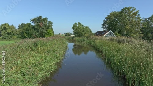 Aerial view of tranquil countryside with river, farm, and trees, Allingawier, Friesland, Netherlands. photo